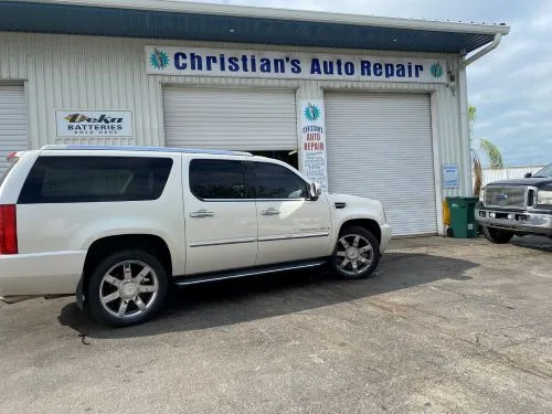 An Escalade and a pickup parked outside the shop